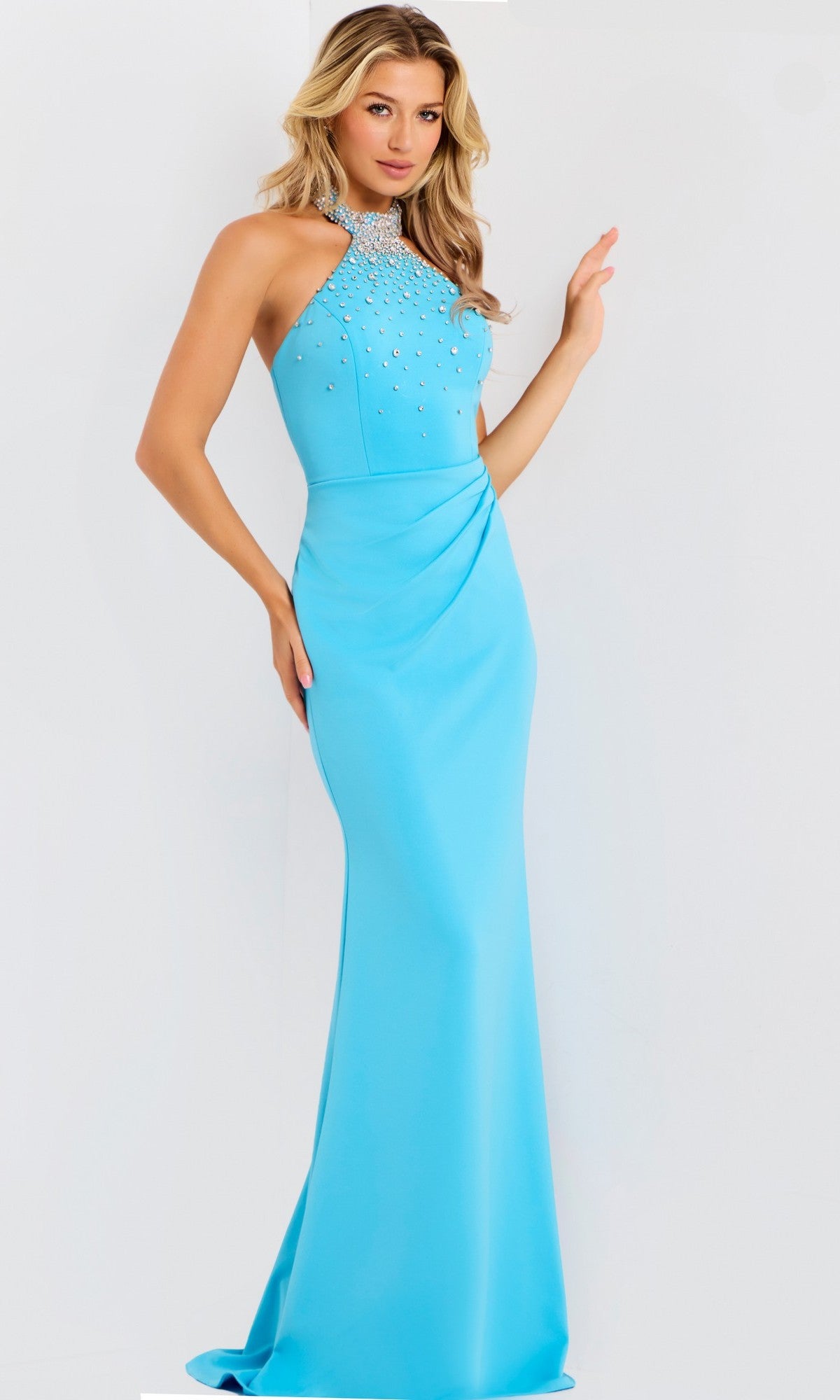 A woman wears the Jovani 45483 long turquoise prom dress, a fitted crepe halter gown with a rhinestone-embellished neckline, standing against a plain white background.